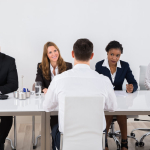 Businesspeople Interviewing Man